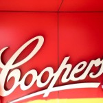 two people standing next to the Coopers logo