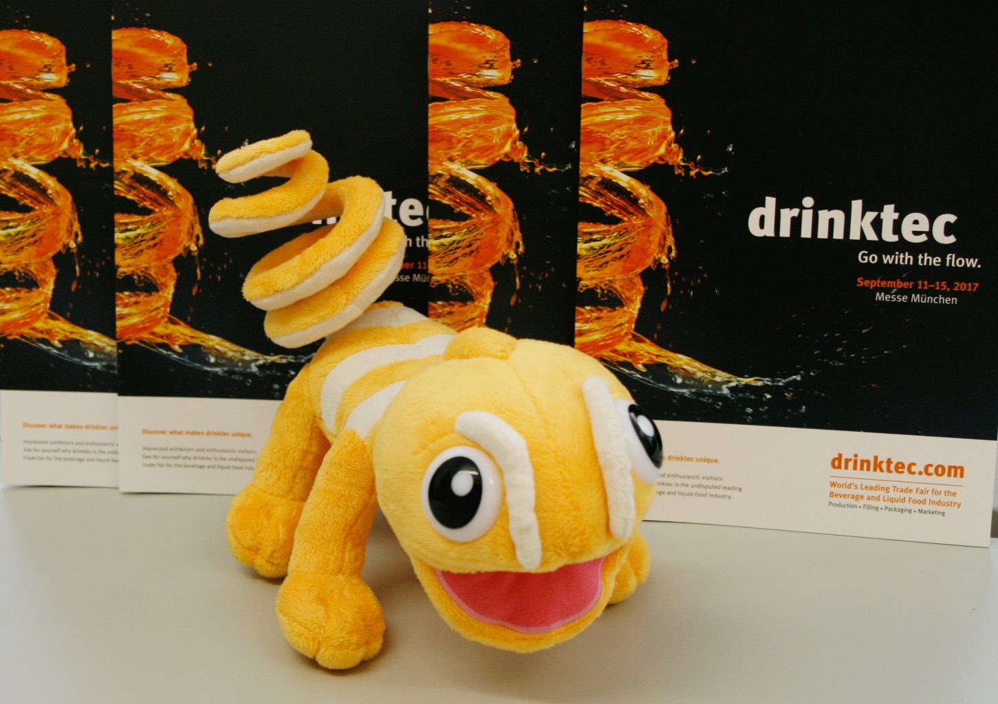 a stuffed animal on a table in front of drinktec brochures