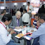 some men sitting on a table and working at the drinktec India