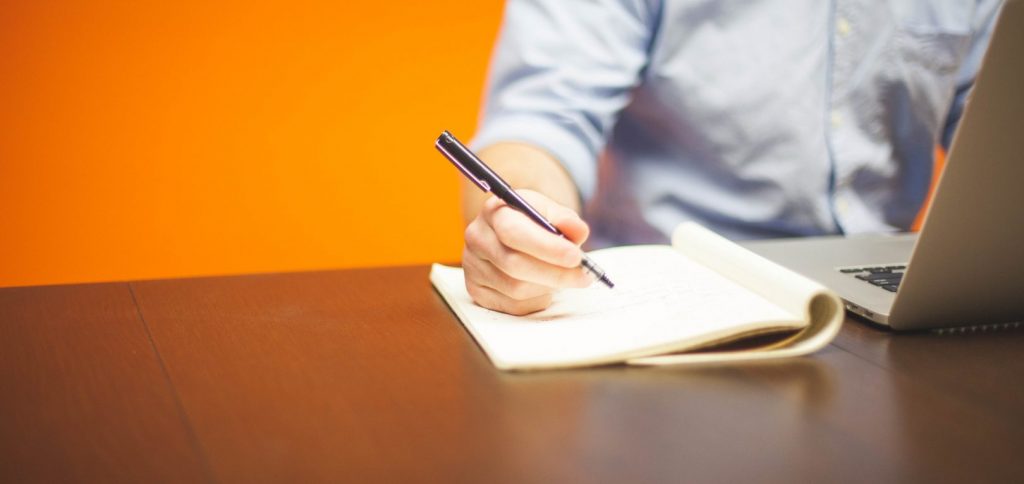 A person writing something into a note book