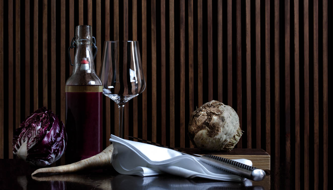 A wine glas and a bottle on a table