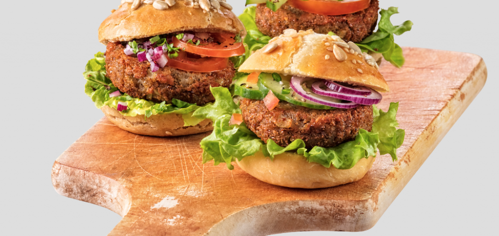 Three delicious looking burgers on a cutting board